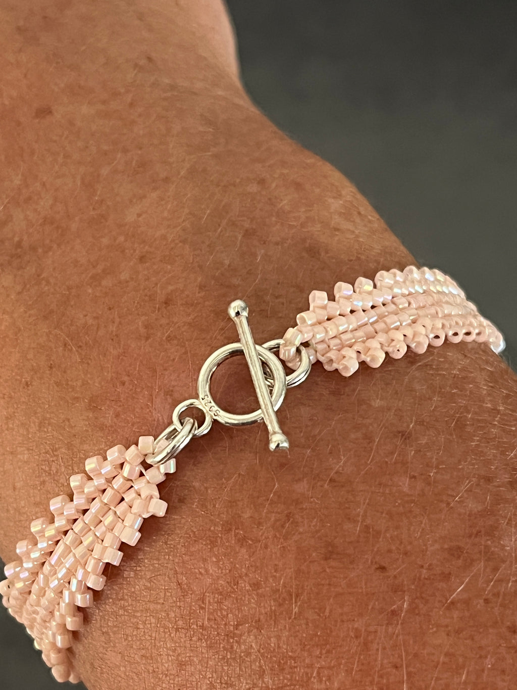 Bracelet Camélia rose artisanal porté, détail du design élégant