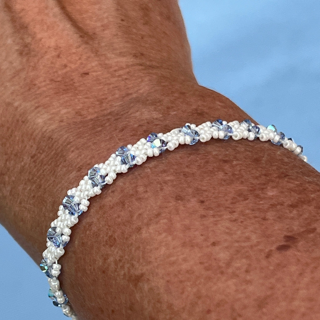 Bracelet Clématite artisanal porté au poignet, cristaux Swarovski bleu ciel