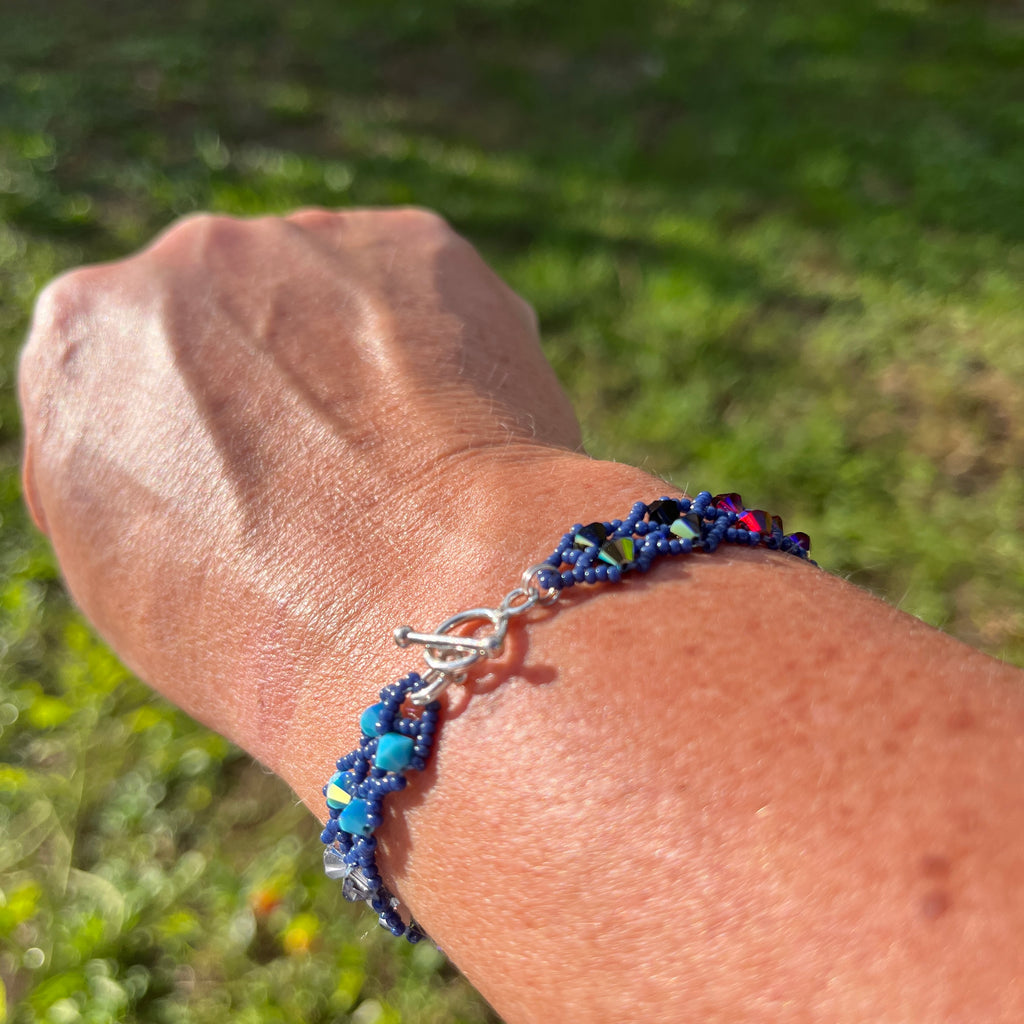 Bracelet Iris artisanal porté au poignet, cristaux Swarovski multicolores