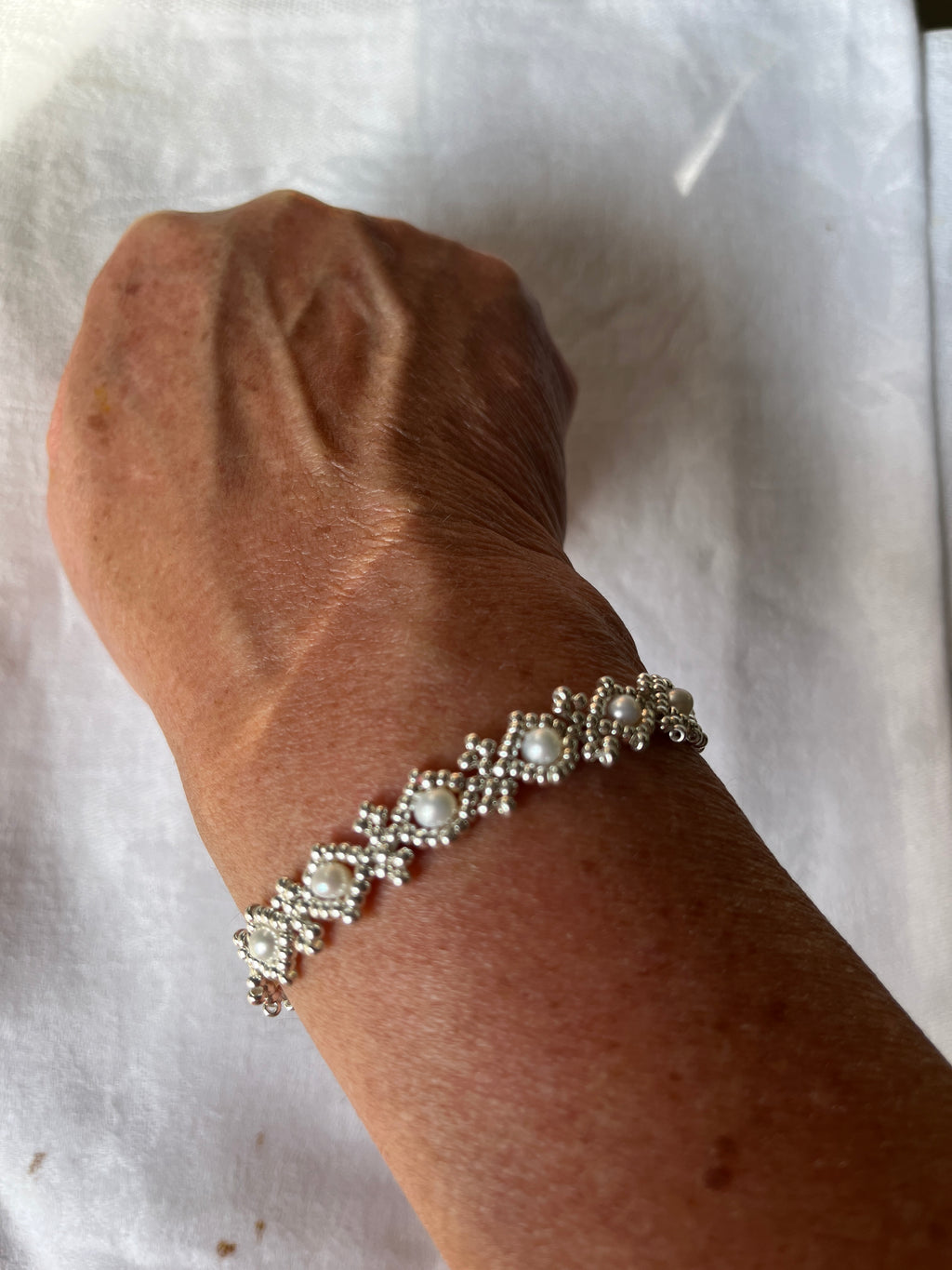 Bracelet Orchidée artisanal porté en perles Miyuki, cristaux Swarovski et perles d'eau douce, fermoir argent 925